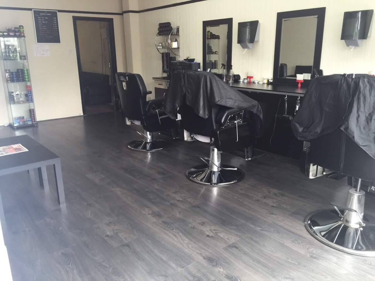 Broadgate Barbers interior with black chairs and cream walls